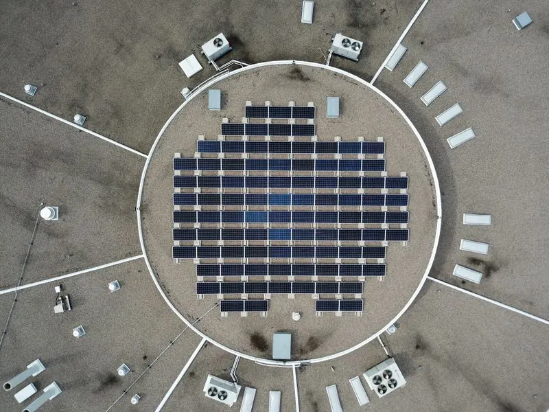Aerial view of a circular solar array surrounded by gravel